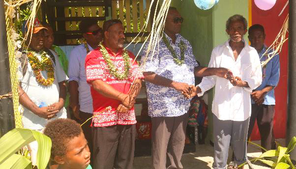 (l-R) Contractor, PS MECCDM, MPA, PS MPGIS, Hon. Premier Central Province, Village Chief, & Rara Head Master during cutting of ribbon and handing over of keys to the classrooms.